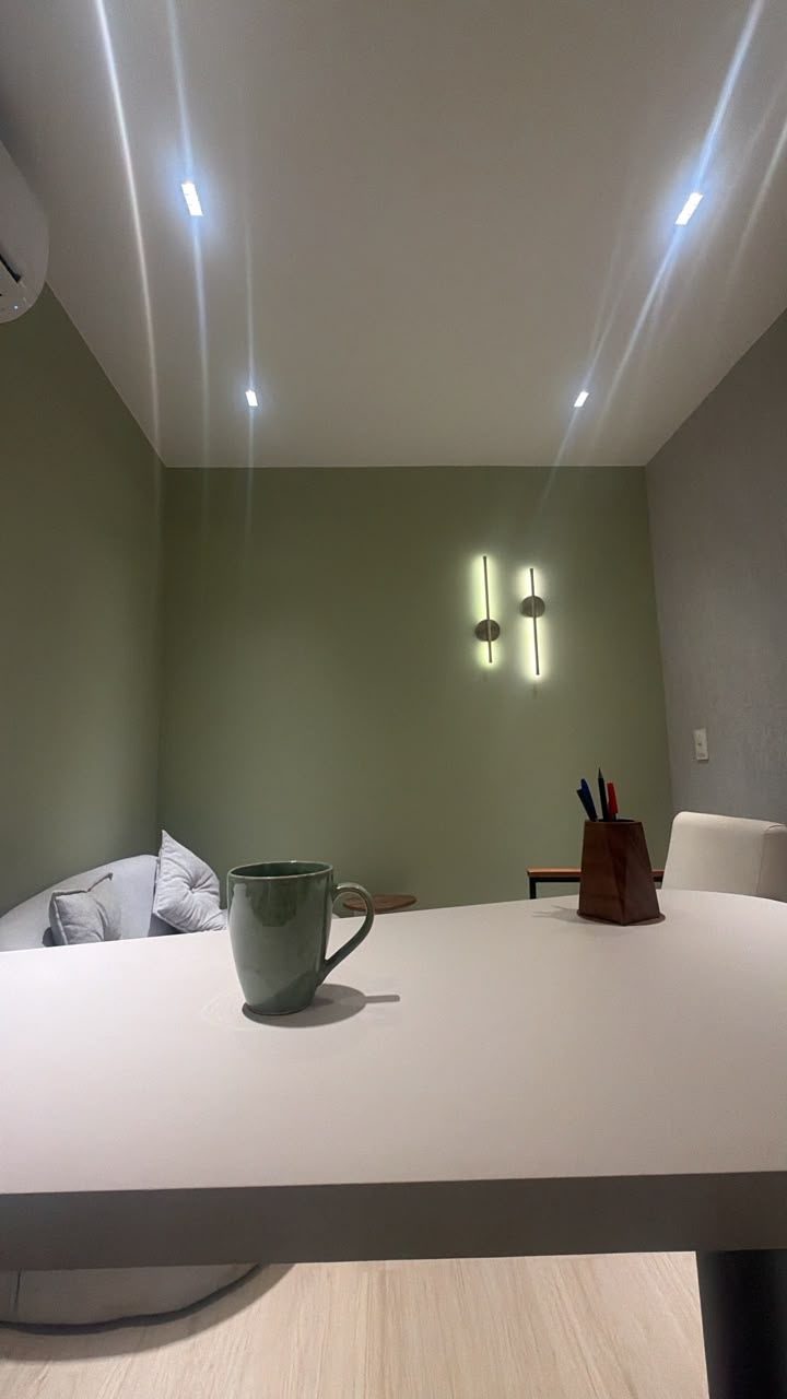 Mesa da sala adulta com luminárias de parede acesas