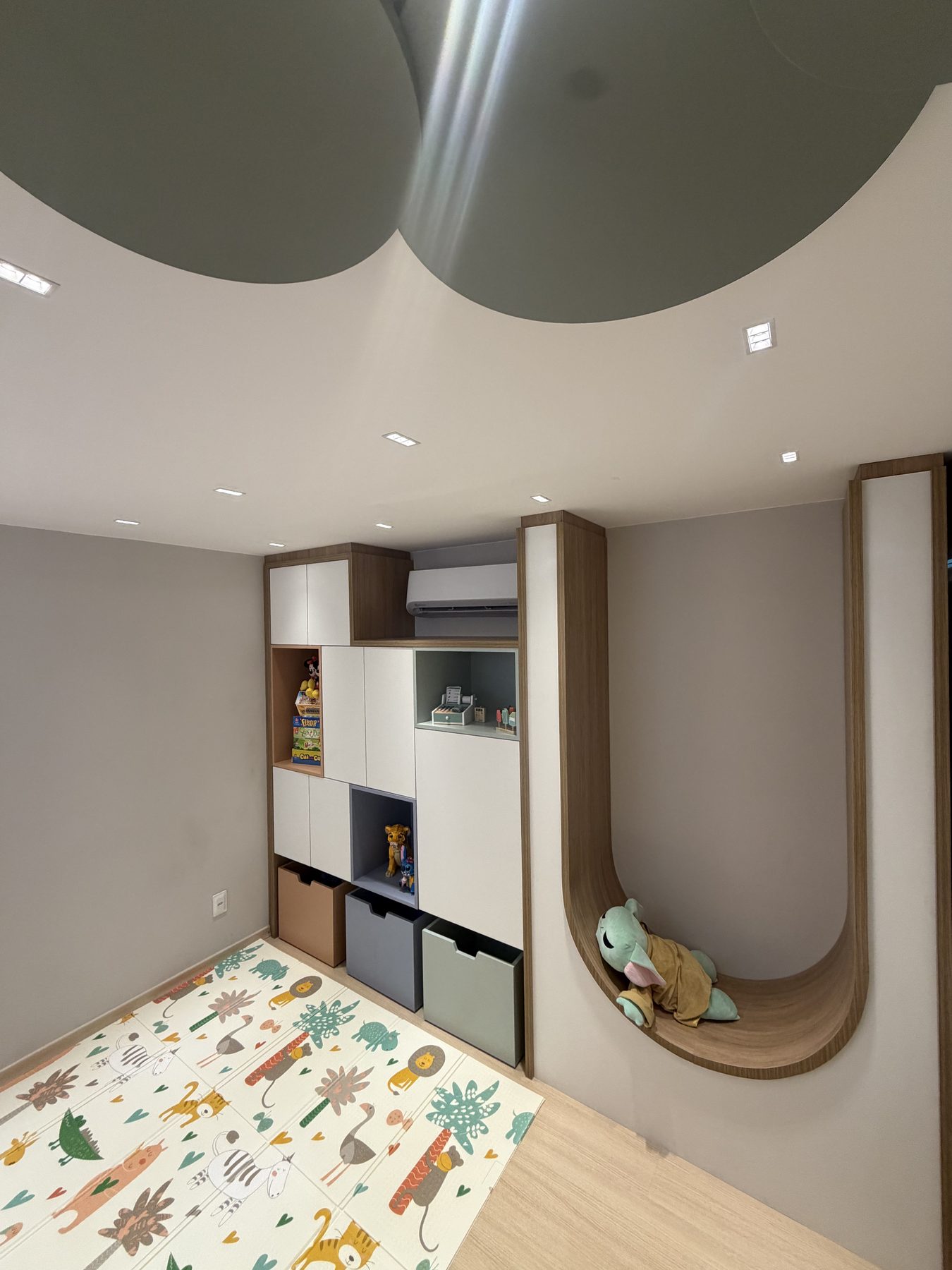Sala infantil da Casa Telos com tapete de brincar, marcenaria sob medida e forro de nuvens