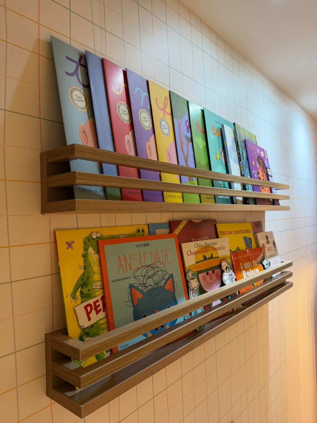 Prateleiras de madeira com livros infantis coloridos